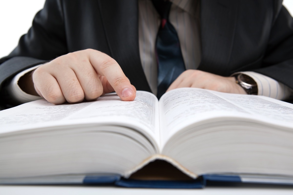 man looking up the best insults in the dictionary