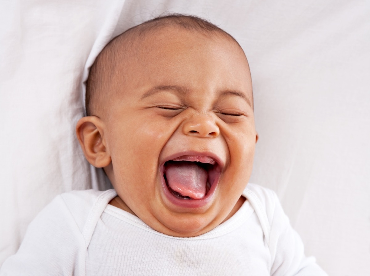 smiling baby in white onesie