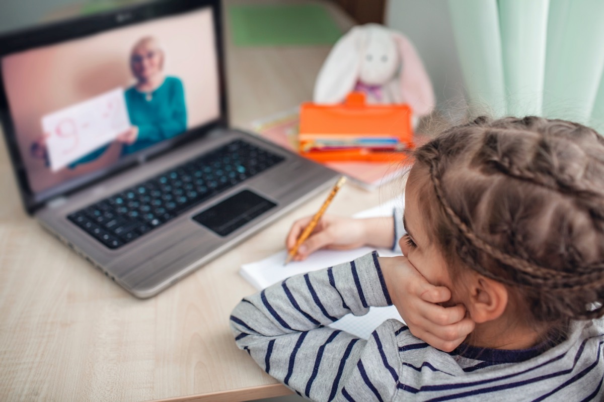 schoolgirl studying homework math during her online lesson at home,