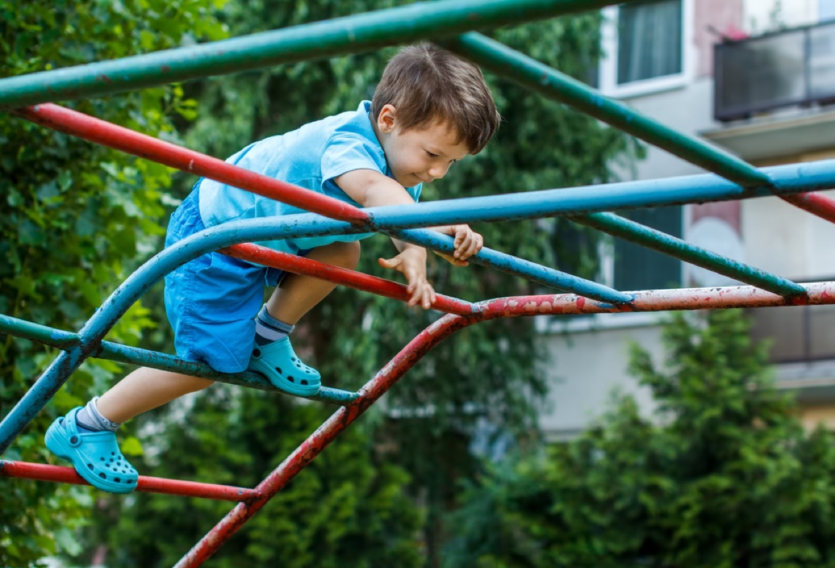 young child climbing on playground, backyard dangers