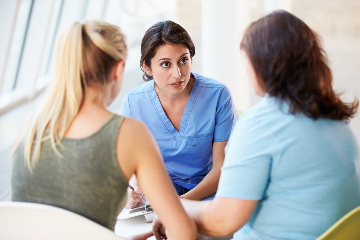 Nurse Meeting With Teenage Girl And Mother In Hospital