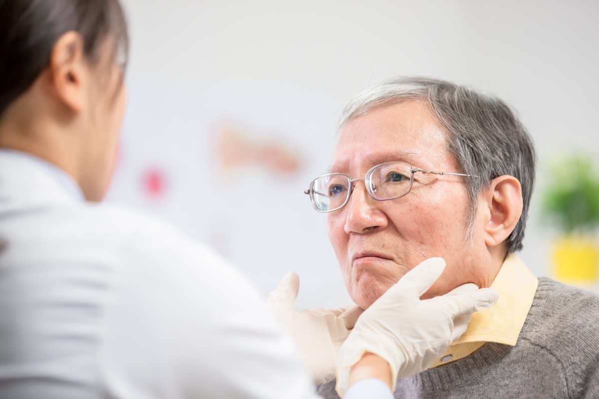 Female doctor check throat for elder patient carefully