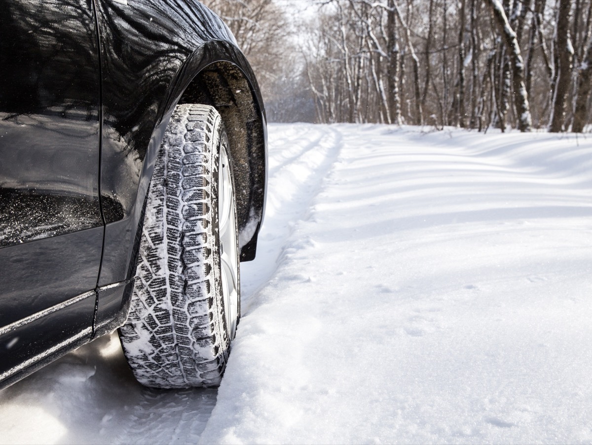 Driving SUV car in winter on forest road with much snow