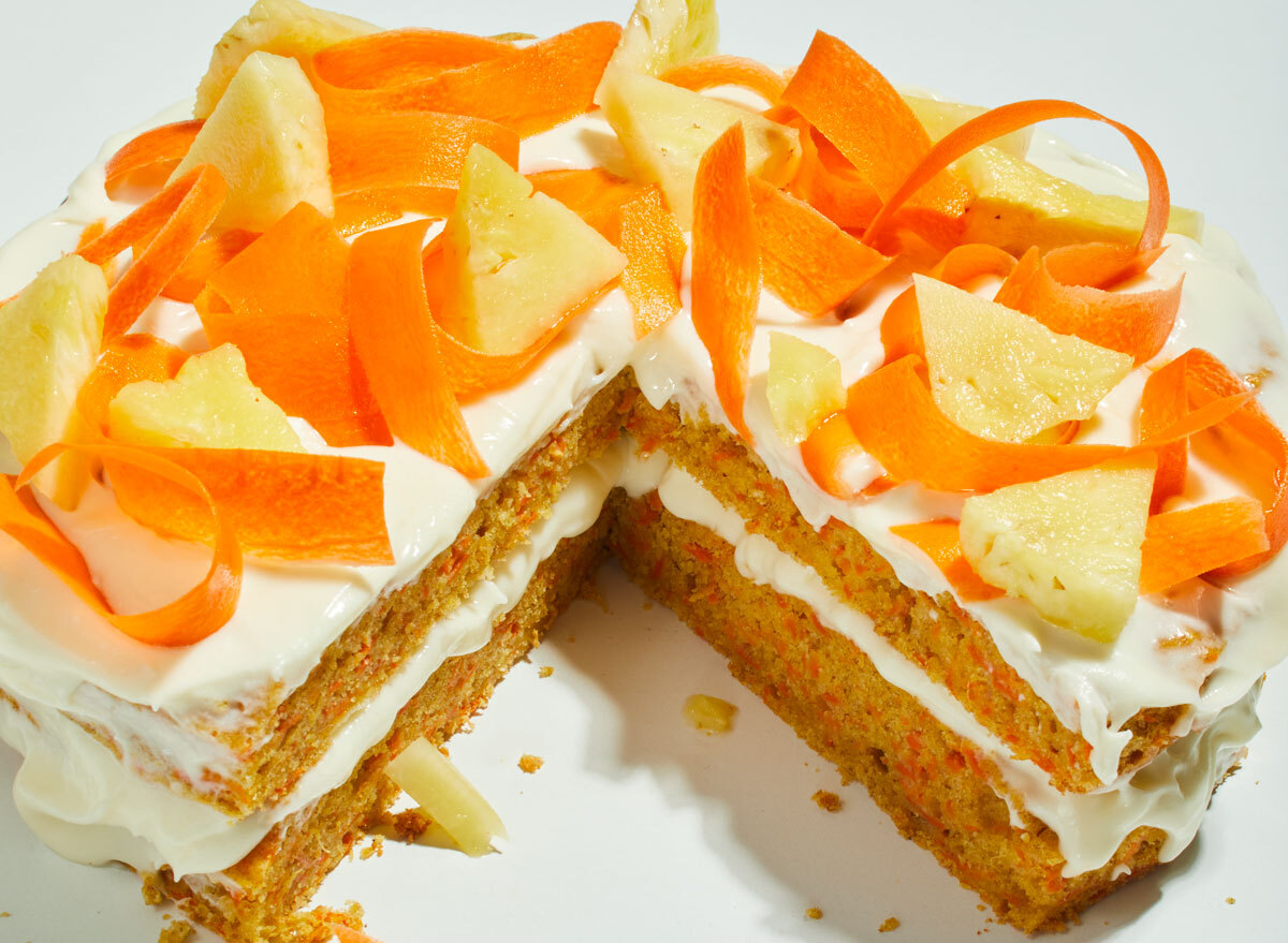 ginger carrot pineapple cake sliced with carrot and pineapple toppings on a white table