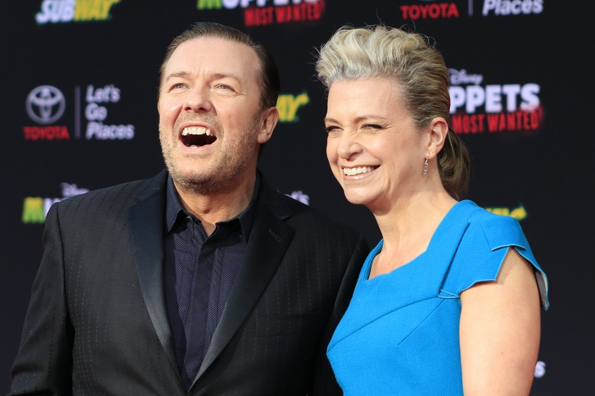 Ricky Gervais wears a black suit and Jane Fallon wears a blue dress at the premiere of 'Muppets Most Wanted' in 2014