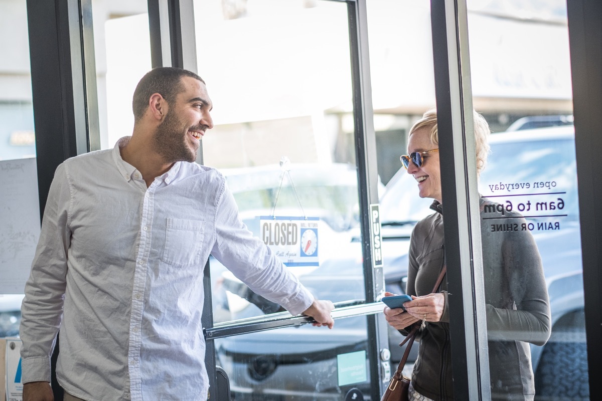 man holding the door open for a woman