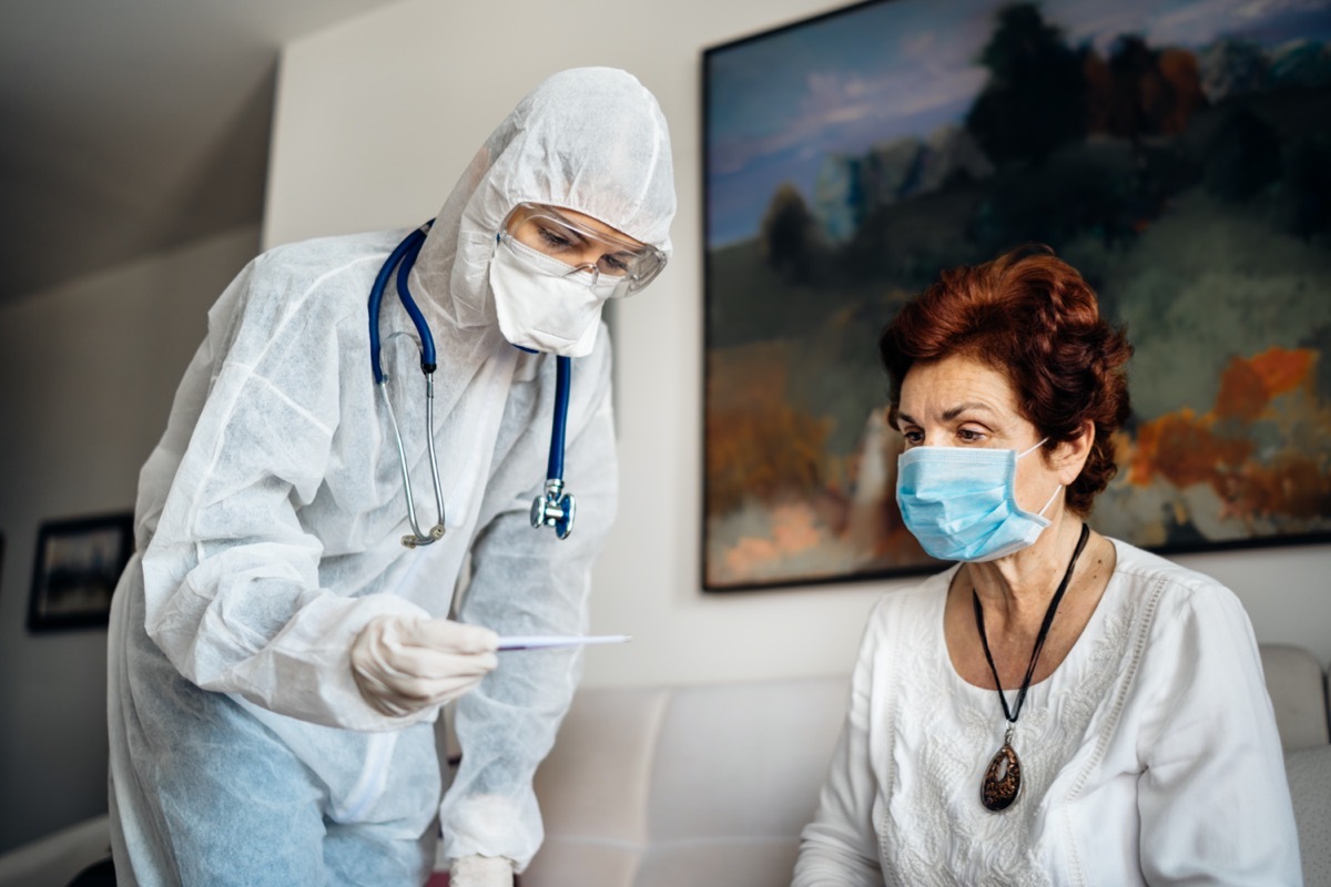 Home care doctor wearing personal protective equipment(PPE).Infection and cross-contamination during home visit to suspect COVID-19 senior patient