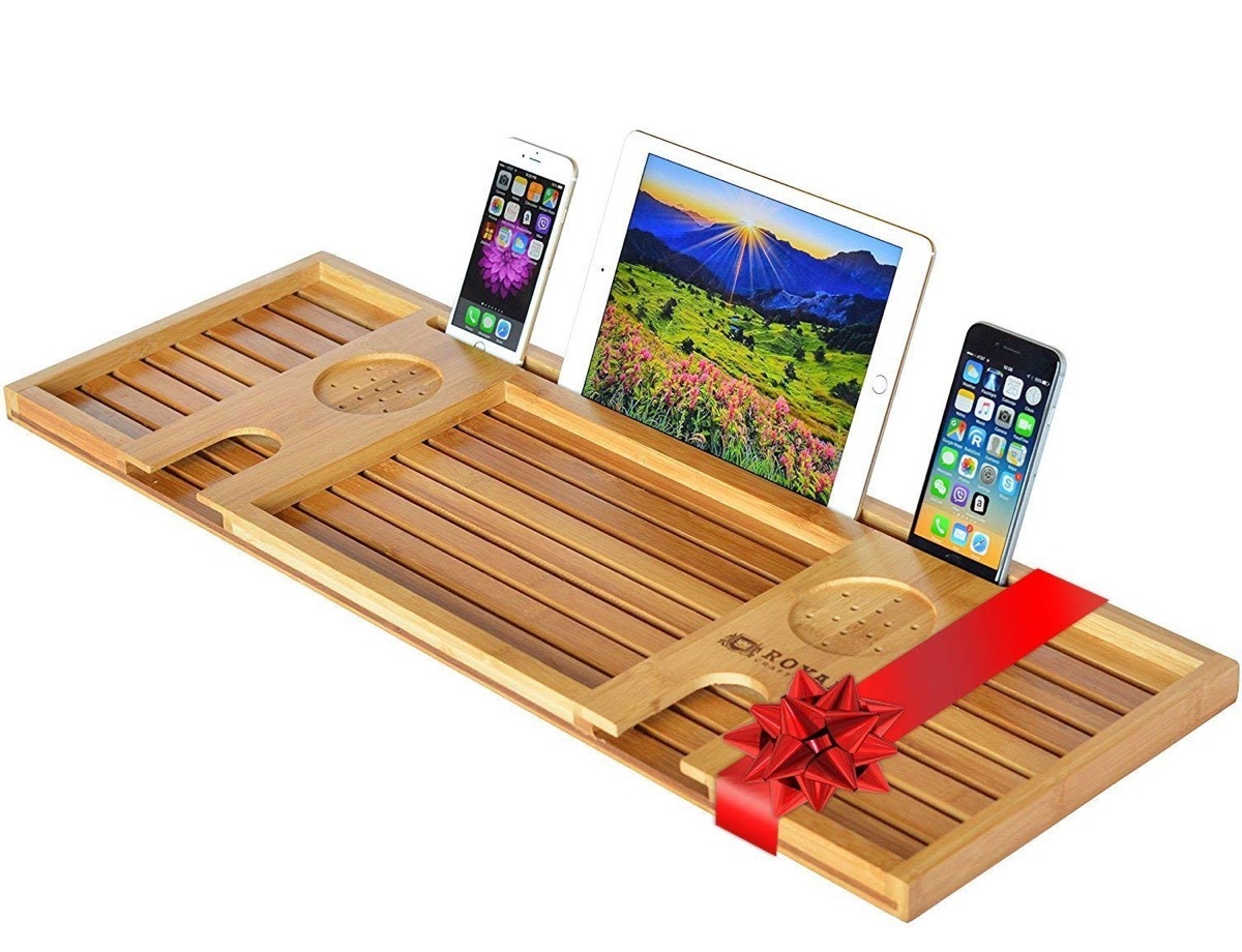 wooden bathtub serving tray with phones and ipad on it