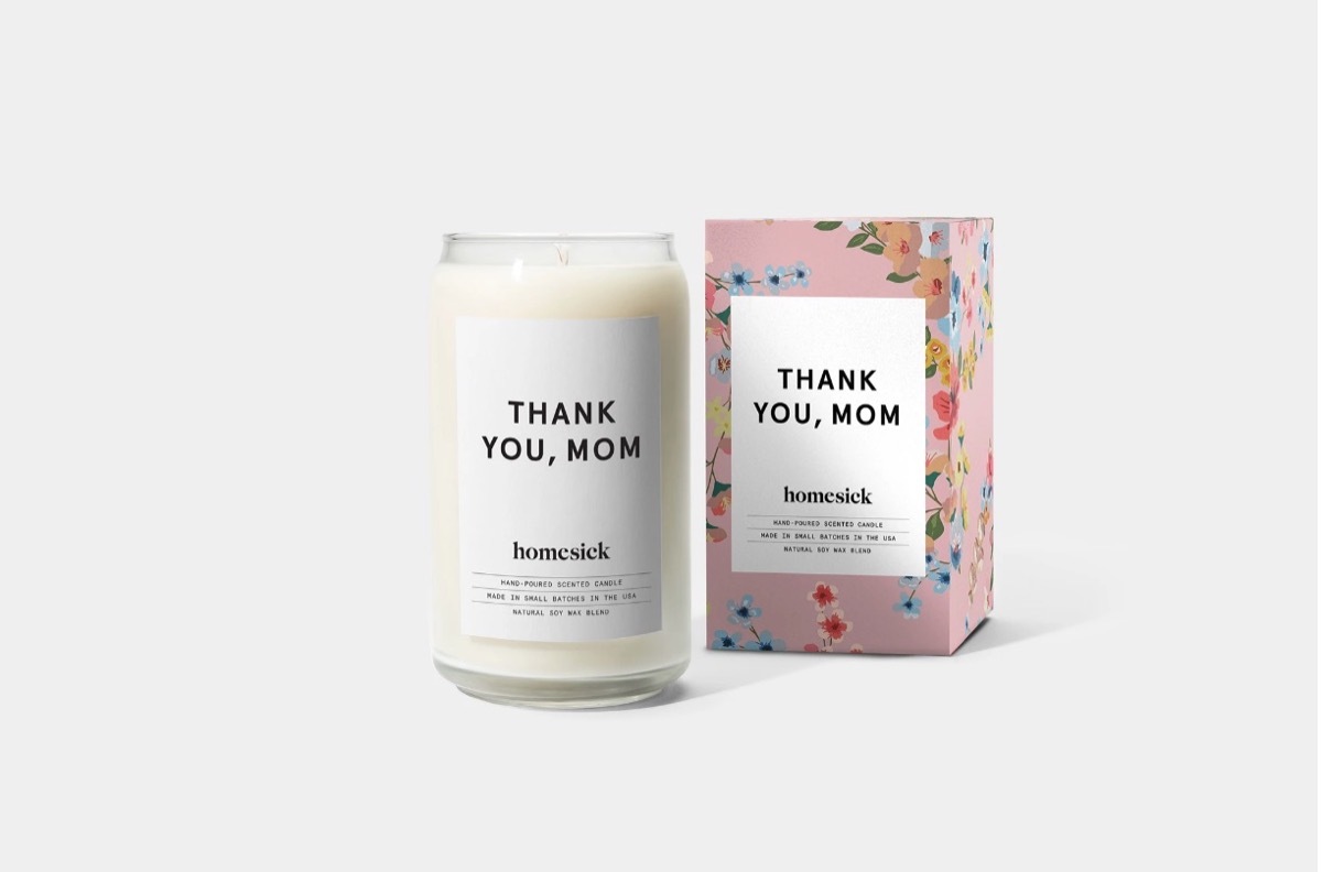 white candle in glass jar and floral box with white labels reading 