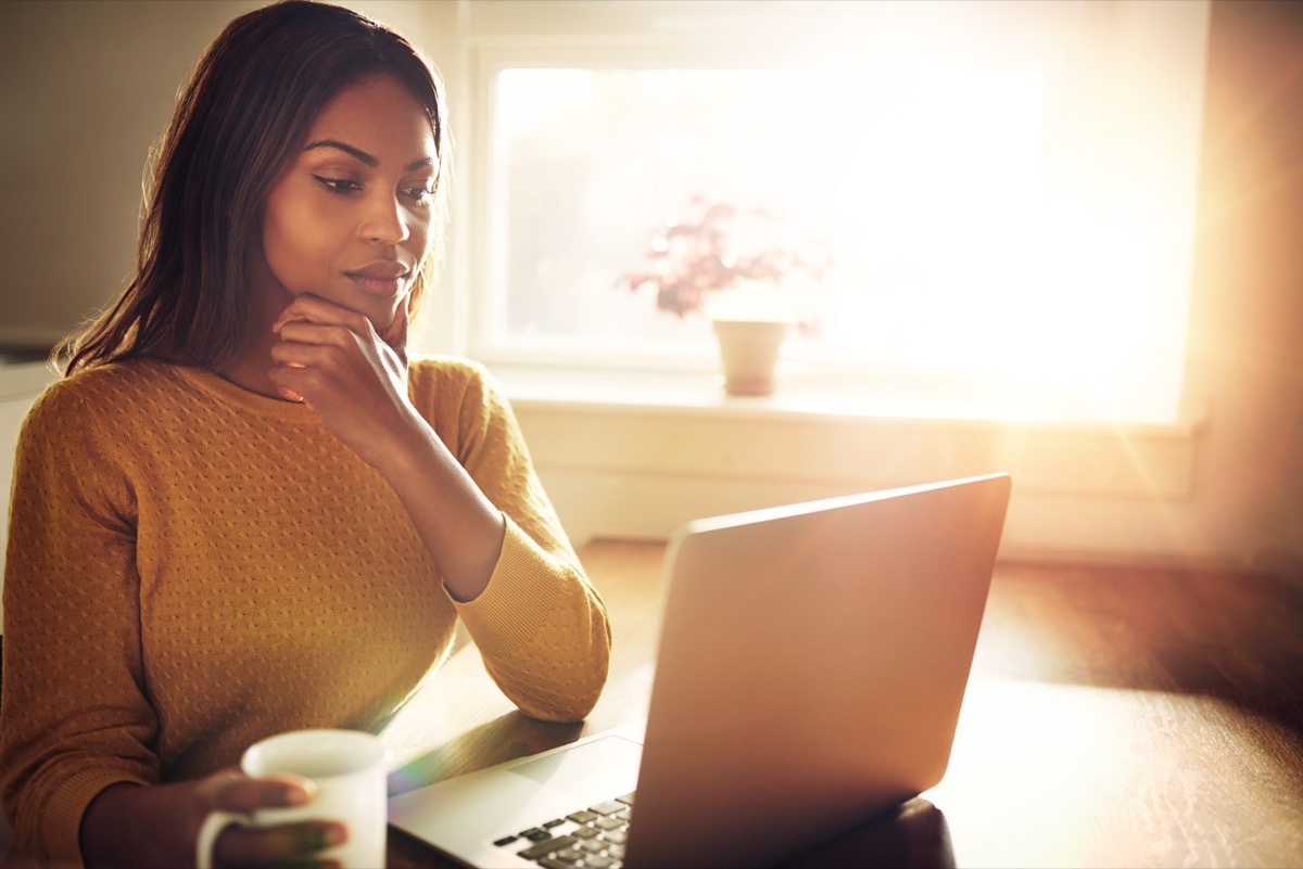 Woman thinking at her desk with laptop