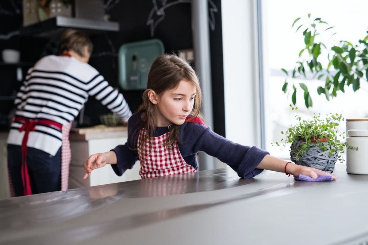 A small girl cooking with grandmother at home.