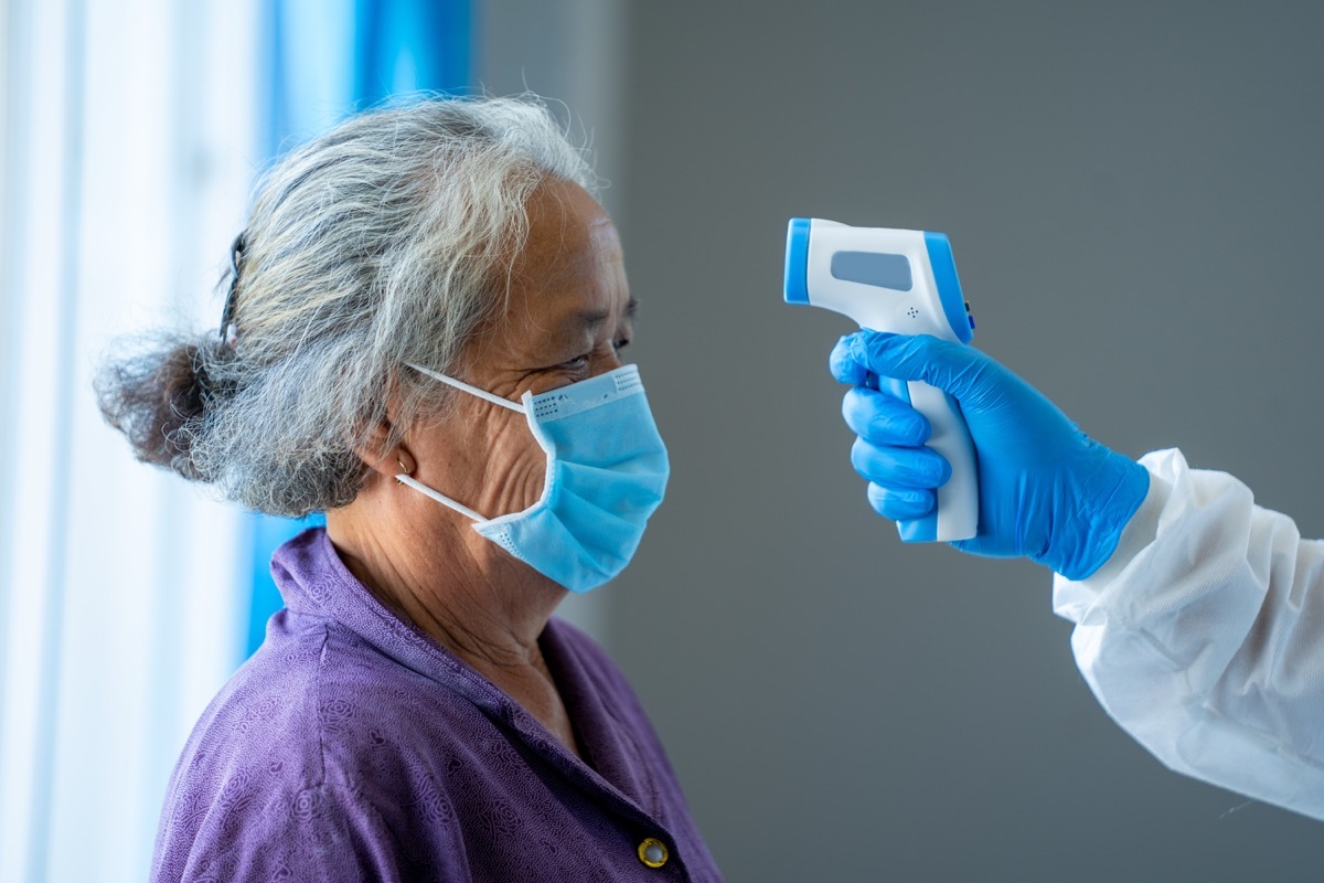 Woman over 65 getting her temperature taken