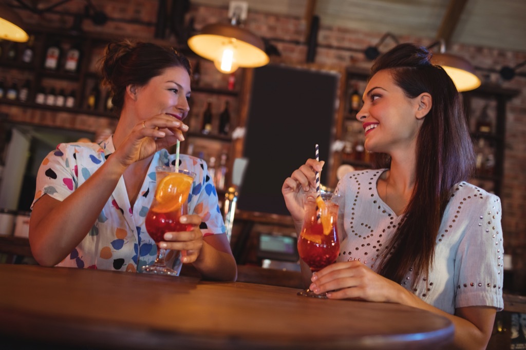 two women having drinks together at a bar, how to make friends as an adult