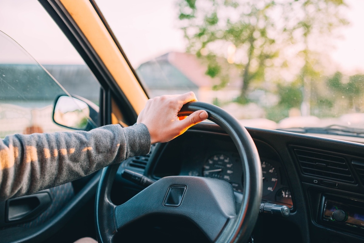 One hand on steering wheel