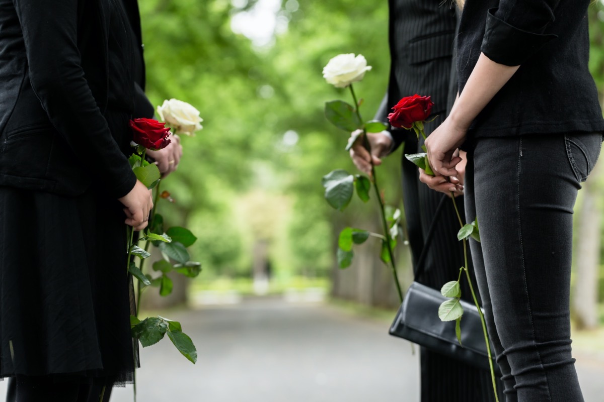 Family in guard of honor at funeral, only torso of people to be seen