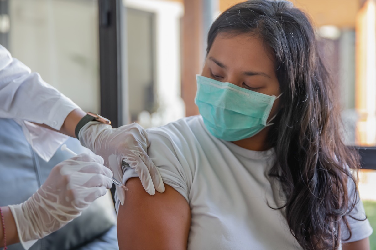 woman receiving covid-19 vaccine at home.